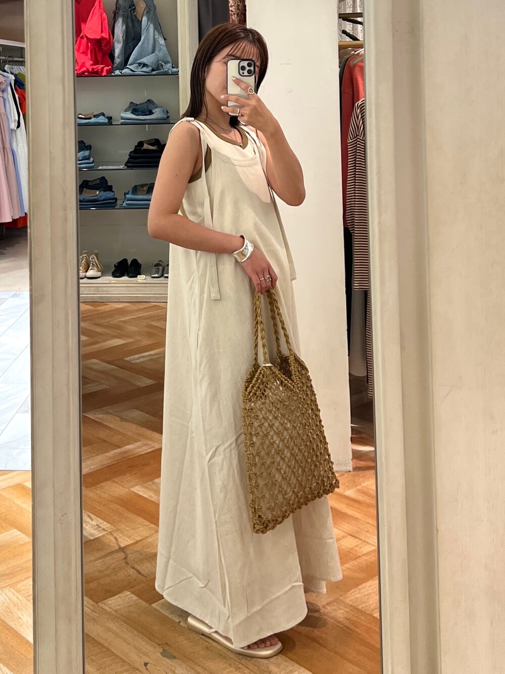ホワイト系のワンピース、ホワイト系のTシャツ/カットソー、ブラウン系のハンドバッグを着用したレディースの夏コーディネートの3枚目の写真