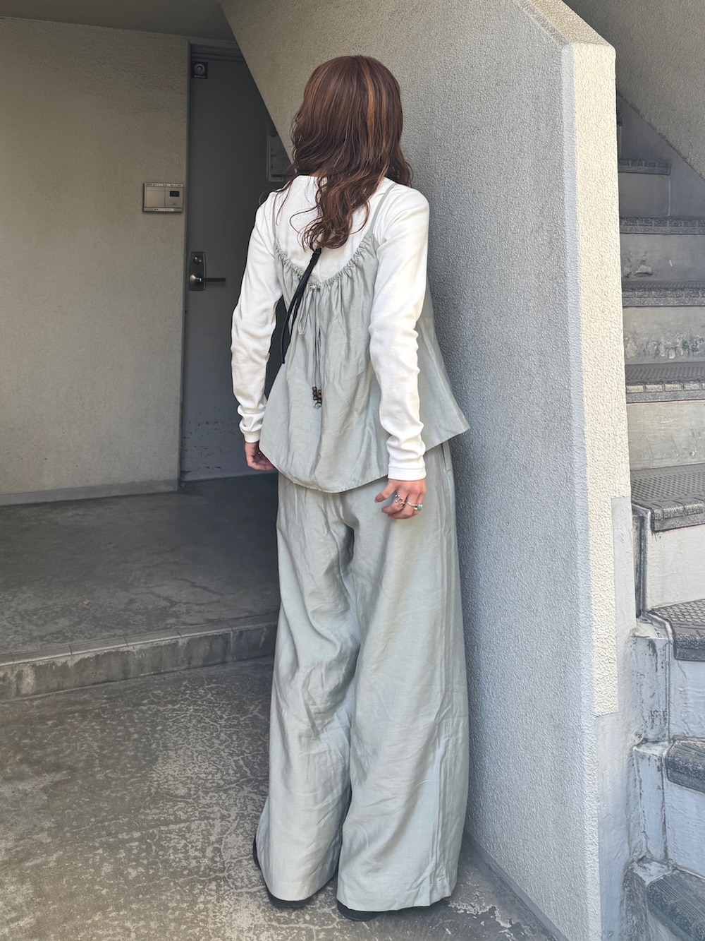 ブルー系のデニムジャケット、ホワイト系のTシャツ/カットソー、グリーン系のキャミソールを着用したレディースの冬コーディネートの6枚目の写真