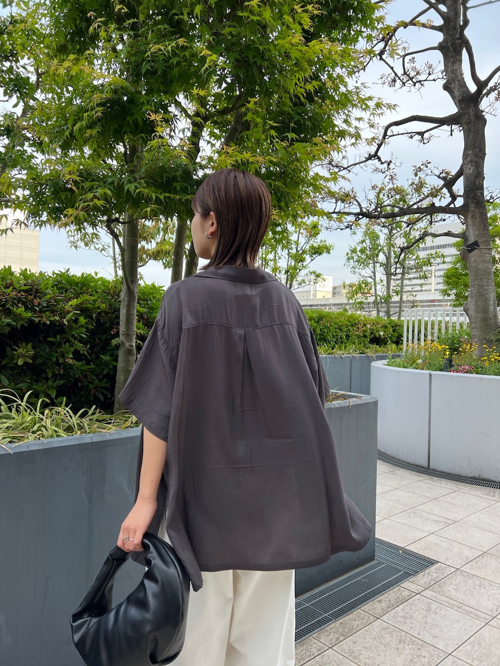グレー系のシャツ/ブラウス、ブラック系のキャミソール、ホワイト系のカーゴパンツを着用したレディースの春コーディネートの6枚目の写真
