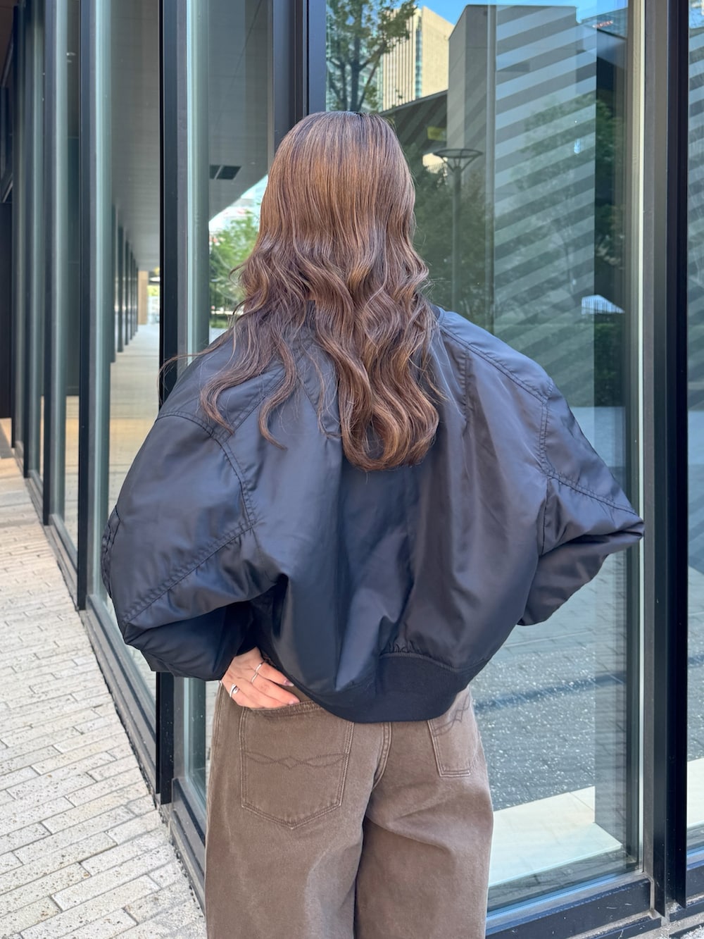 ブラウン系のデニムパンツ、ホワイト系のTシャツ/カットソー、ブラック系のMA-1を着用したレディースの秋コーディネートの8枚目の写真
