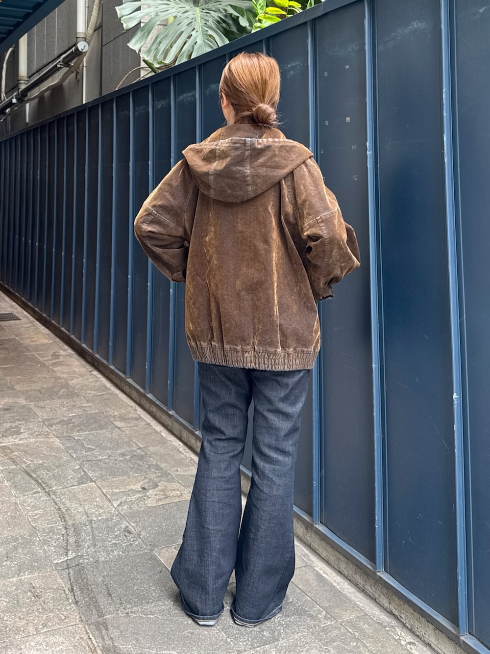 ブラック系のニット/セーター、ブラウン系のブルゾン、ブルー系のデニムパンツを着用したレディースの秋コーディネートの3枚目の写真