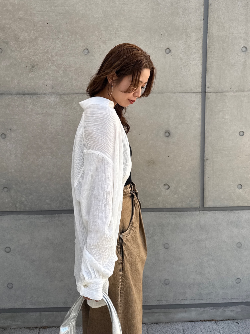 ブラウン系のデニムパンツ、ホワイト系のシャツ/ブラウスを着用したレディースの春コーディネートの9枚目の写真