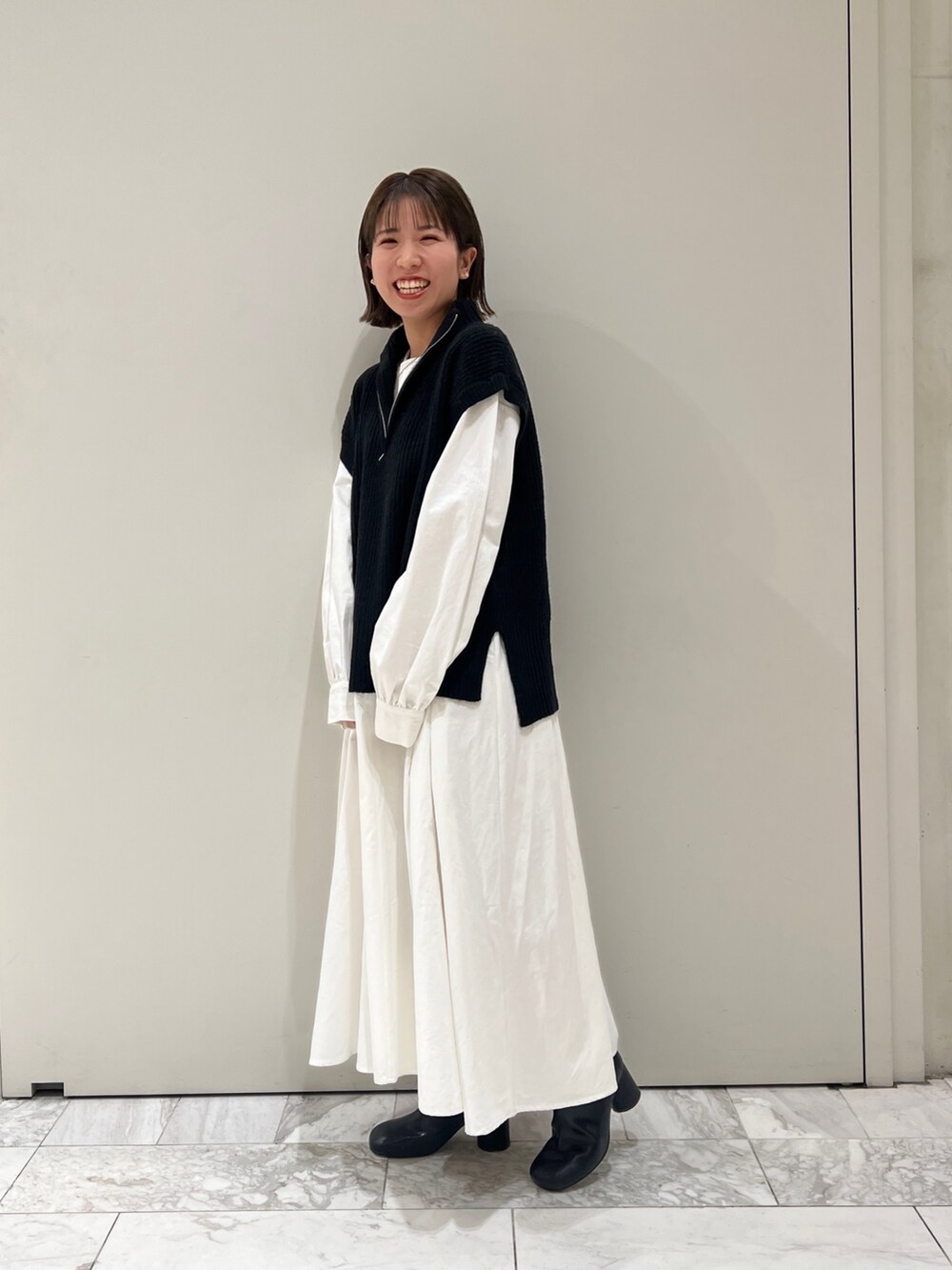 ブラック系のニット/セーター、ブラック系のワンピース、ブラック系のブーツを着用したレディースの冬コーディネートの4枚目の写真