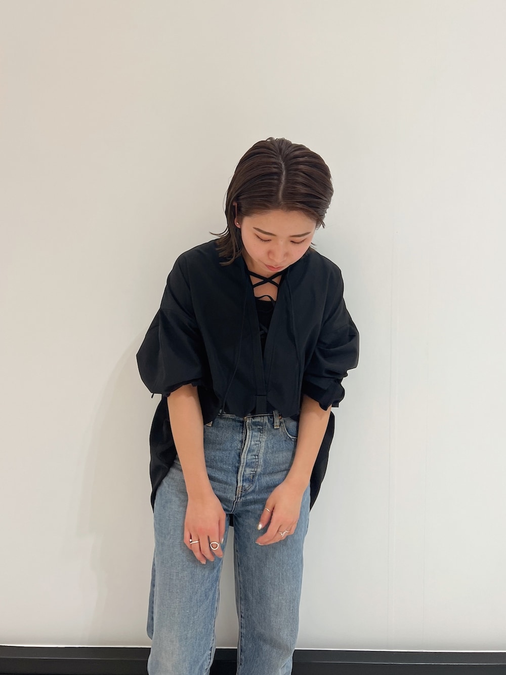 ブラック系のシャツ/ブラウス、ブルー系のデニムパンツ、イエロー系のサンダルを着用したレディースの春コーディネートの5枚目の写真