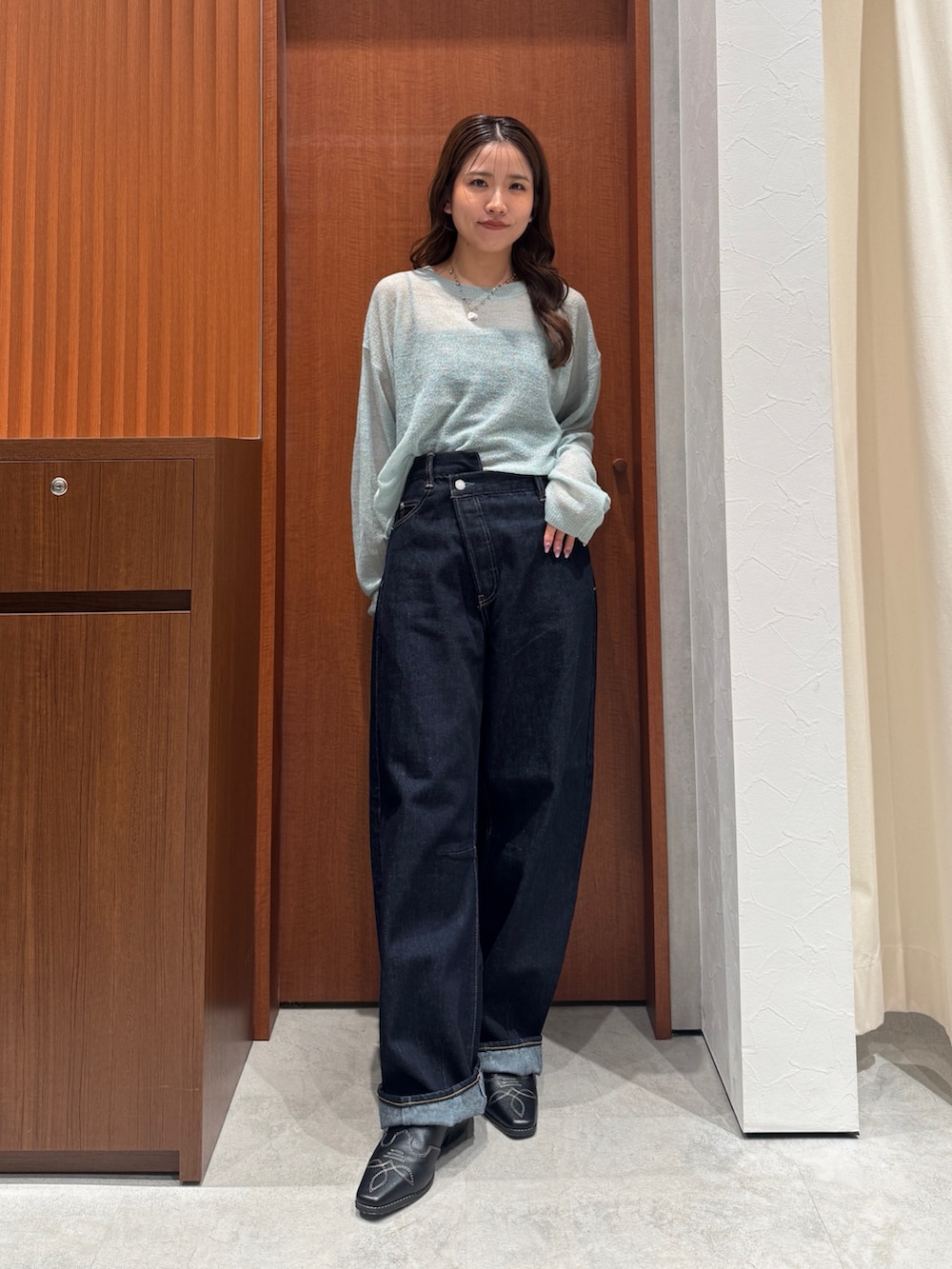 グリーン系のニット/セーター、ブルー系のデニムパンツ、ブラック系のその他シューズを着用したレディースの秋コーディネートの6枚目の写真