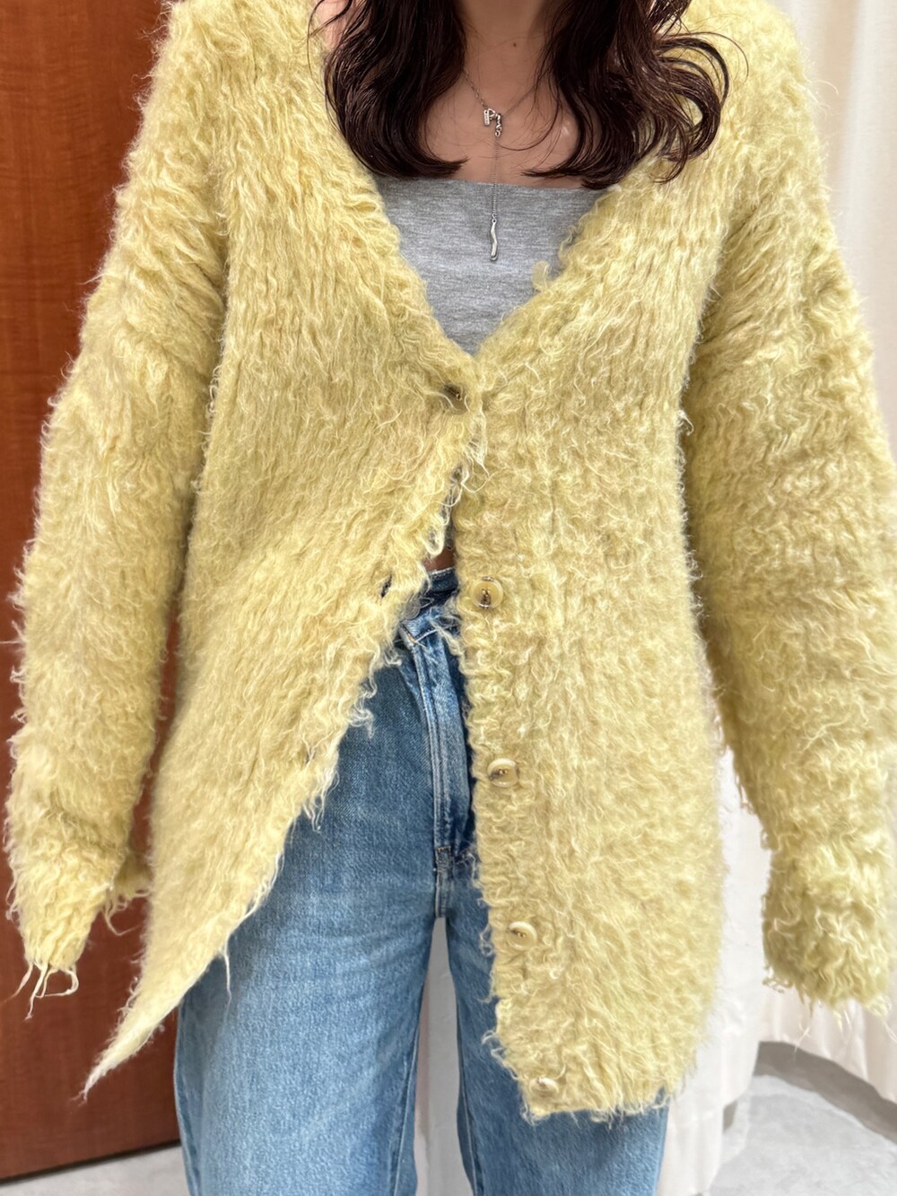 ブルー系のデニムパンツ、イエロー系のカーディガン/ボレロを着用したレディースの秋コーディネートの9枚目の写真