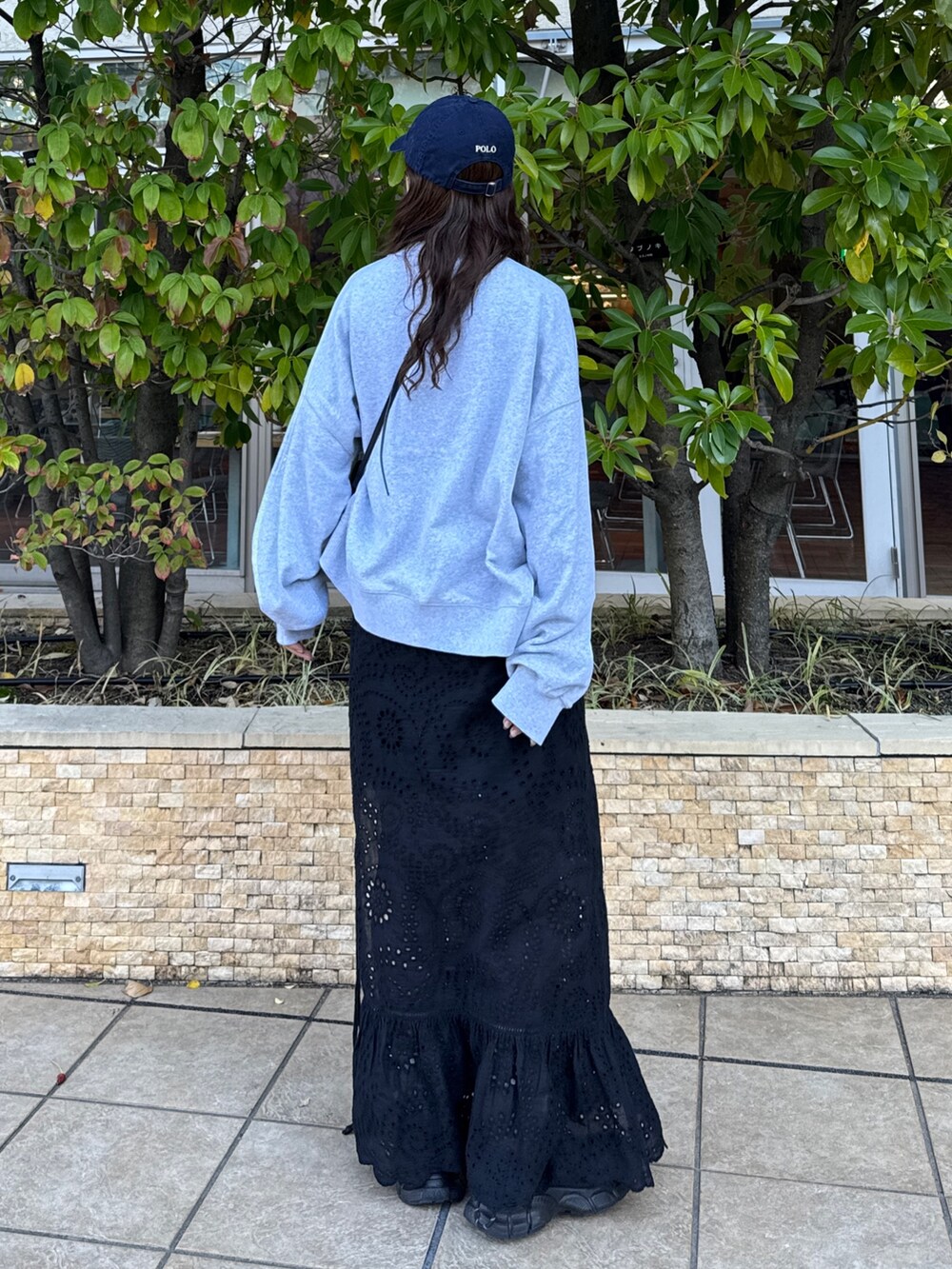 ブラック系のスカート、グレー系のスウェット、ブラック系のスニーカーを着用したレディースの冬コーディネートの5枚目の写真