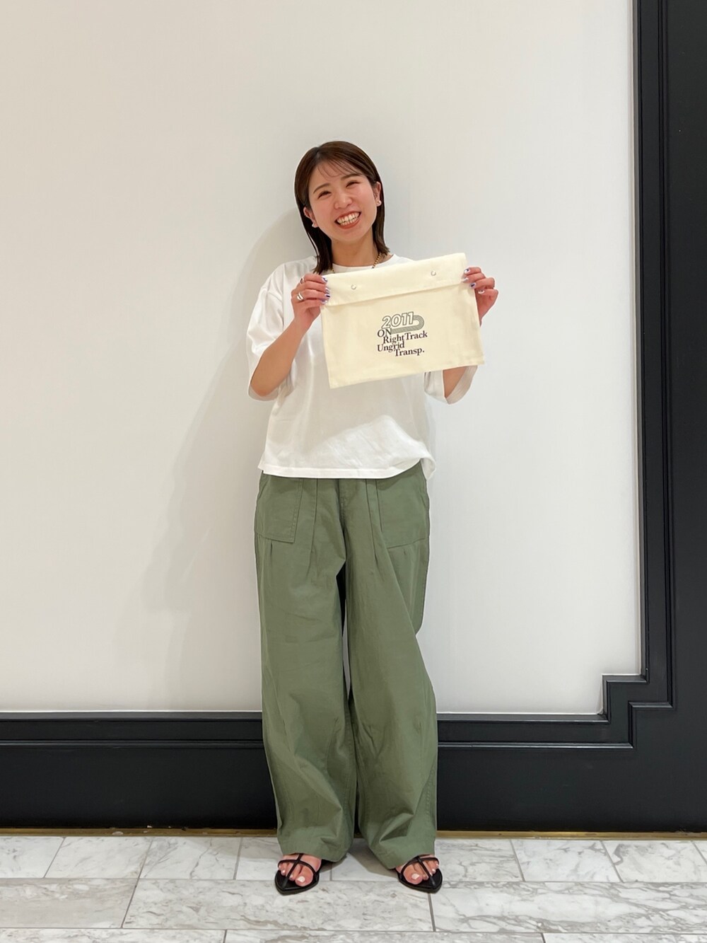 ベージュ系のその他パンツ、ブラック系のサンダル、イエロー系のネックレスを着用したレディースの春コーディネートの6枚目の写真