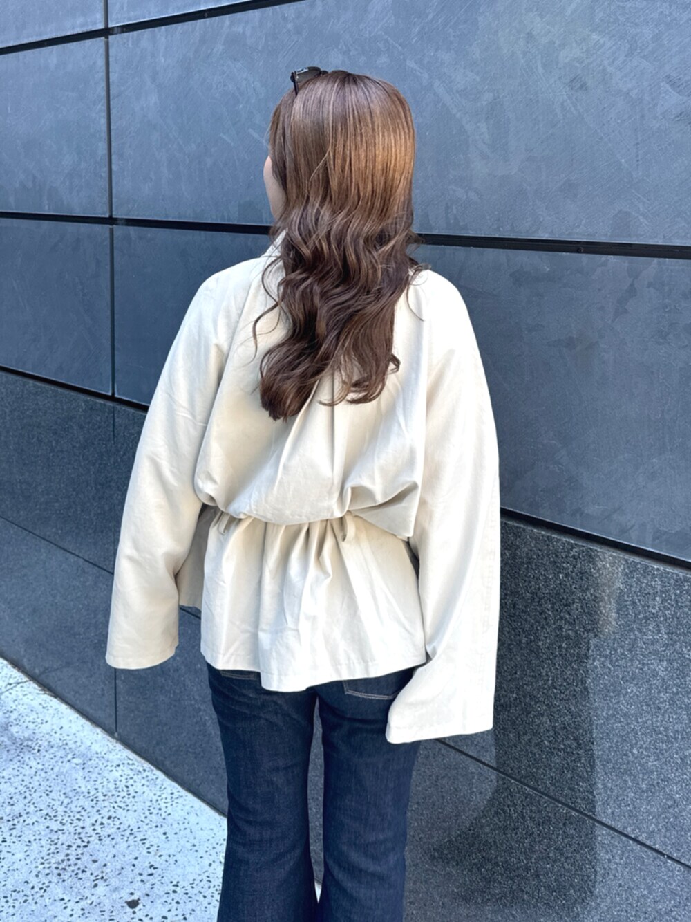 ベージュ系のトレンチコート、ブルー系のデニムパンツ、ブラック系のパンプスを着用したレディースの秋コーディネートの10枚目の写真
