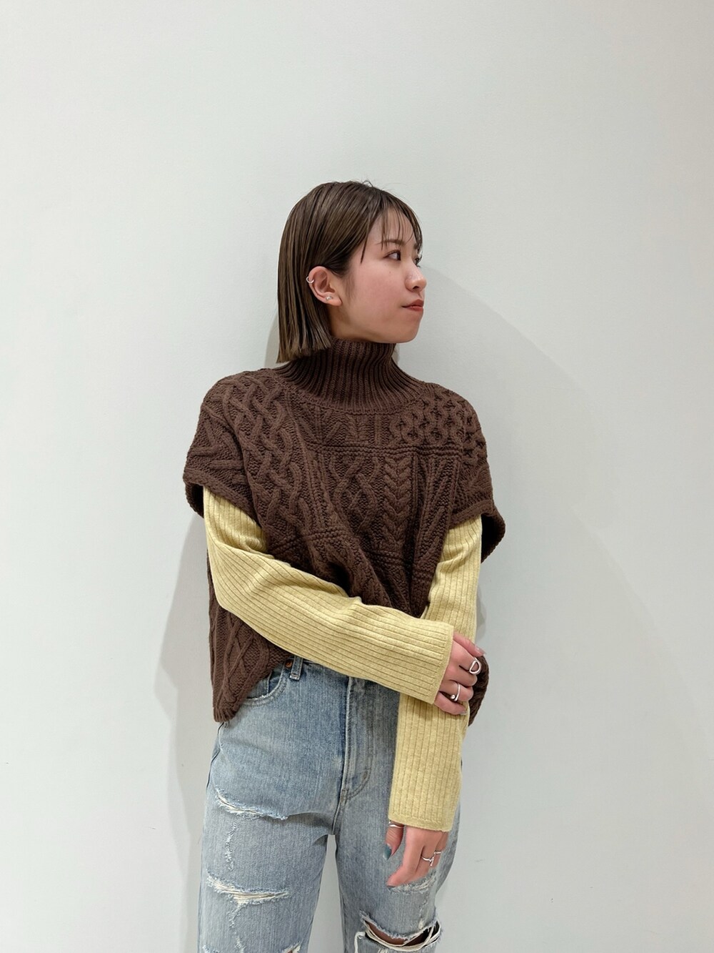 ブラウン系のニット/セーター、ブルー系のデニムパンツ、ブラック系のブーツを着用したレディースの冬コーディネートの8枚目の写真