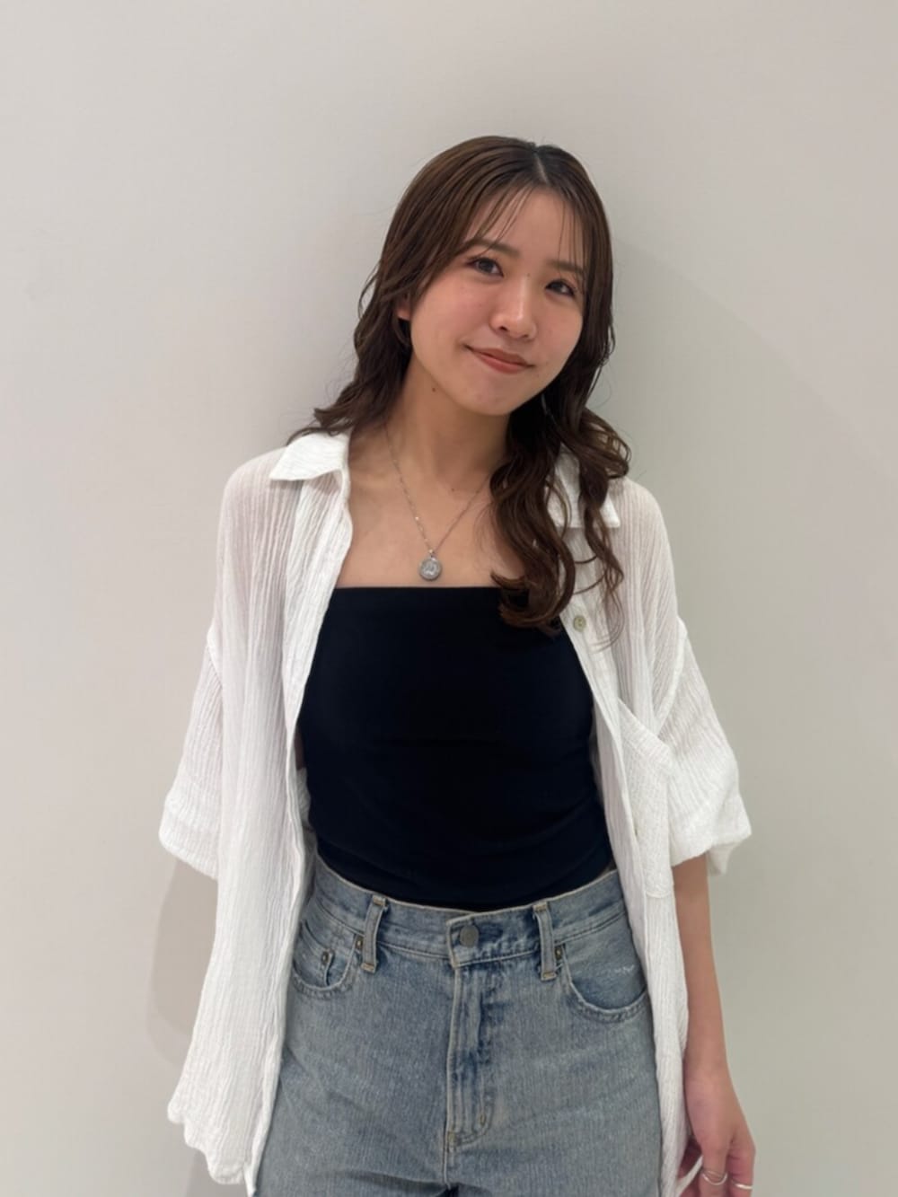 ブラック系のパンプス、ホワイト系のシャツ/ブラウス、ブルー系のデニムパンツを着用したレディースの春コーディネートの10枚目の写真