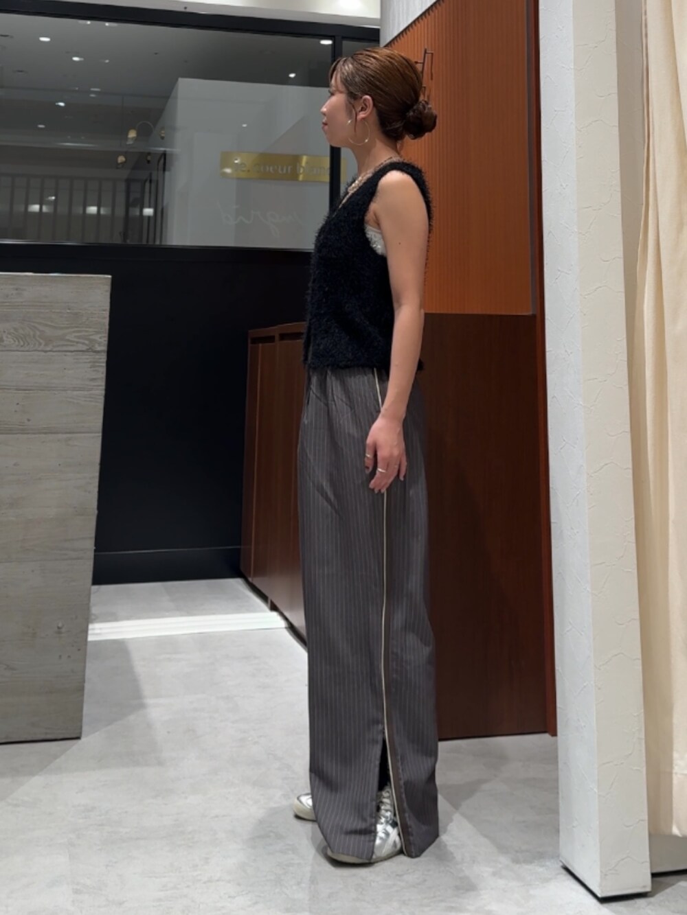 グレー系のその他パンツ、ブラック系のベストを着用したレディースの春コーディネートの8枚目の写真