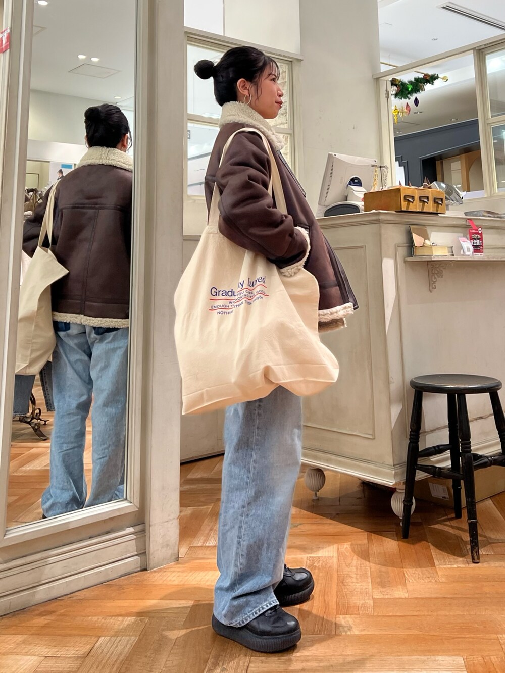 オレンジ系のニット/セーター、ホワイト系のTシャツ/カットソー、ブルー系のデニムパンツを着用したレディースの冬コーディネートの8枚目の写真