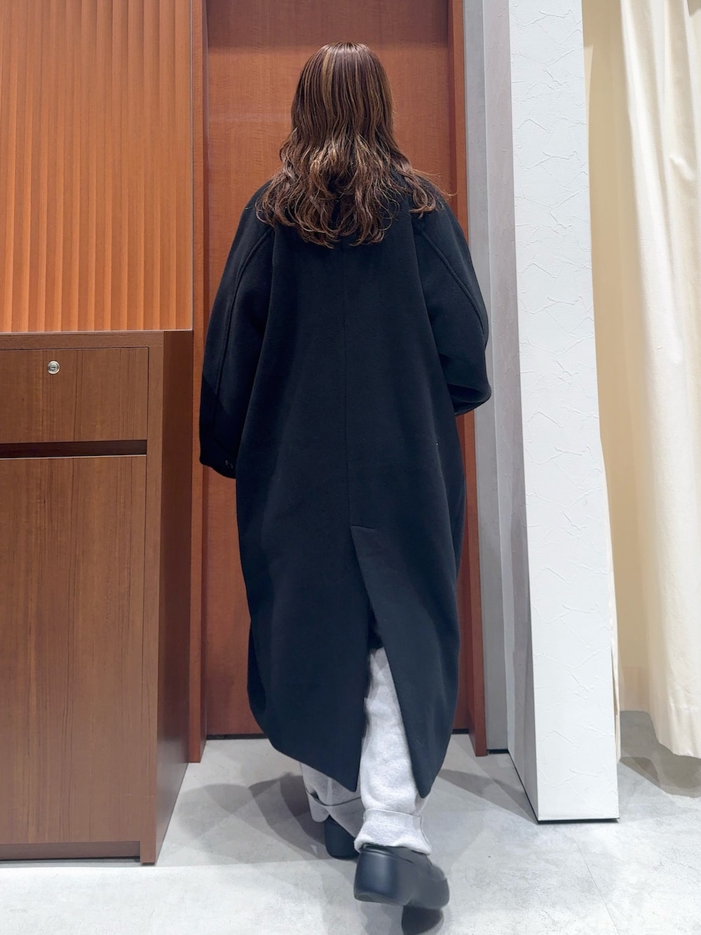 グレー系のカーディガン/ボレロ、グレー系のその他パンツ、ブラック系のチェスターコートを着用したレディースの冬コーディネートの4枚目の写真