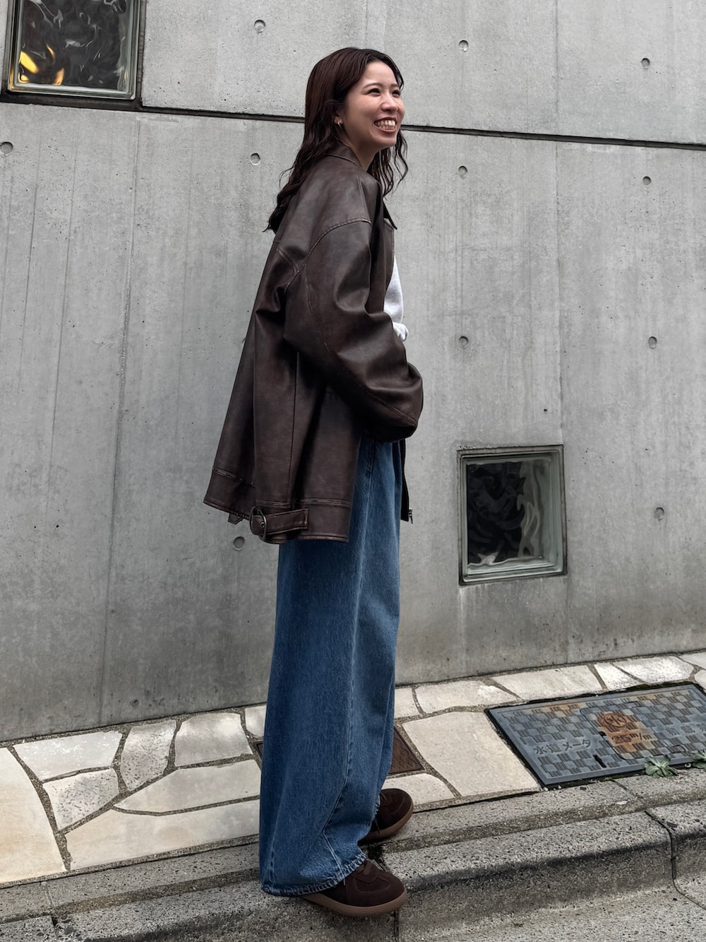 ブルー系のデニムパンツ、グレー系のスウェット、ブラウン系のブルゾンを着用したレディースの秋コーディネートの4枚目の写真