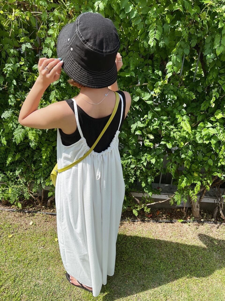 ブラック系のサンダル、ホワイト系のワンピース、ブラック系のタンクトップを着用したレディースの夏コーディネートの5枚目の写真