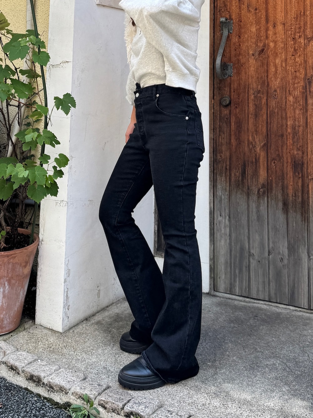 ブラック系のデニムパンツ、グレー系のスウェット、ホワイト系のハンドバッグを着用したレディースの夏コーディネートの7枚目の写真