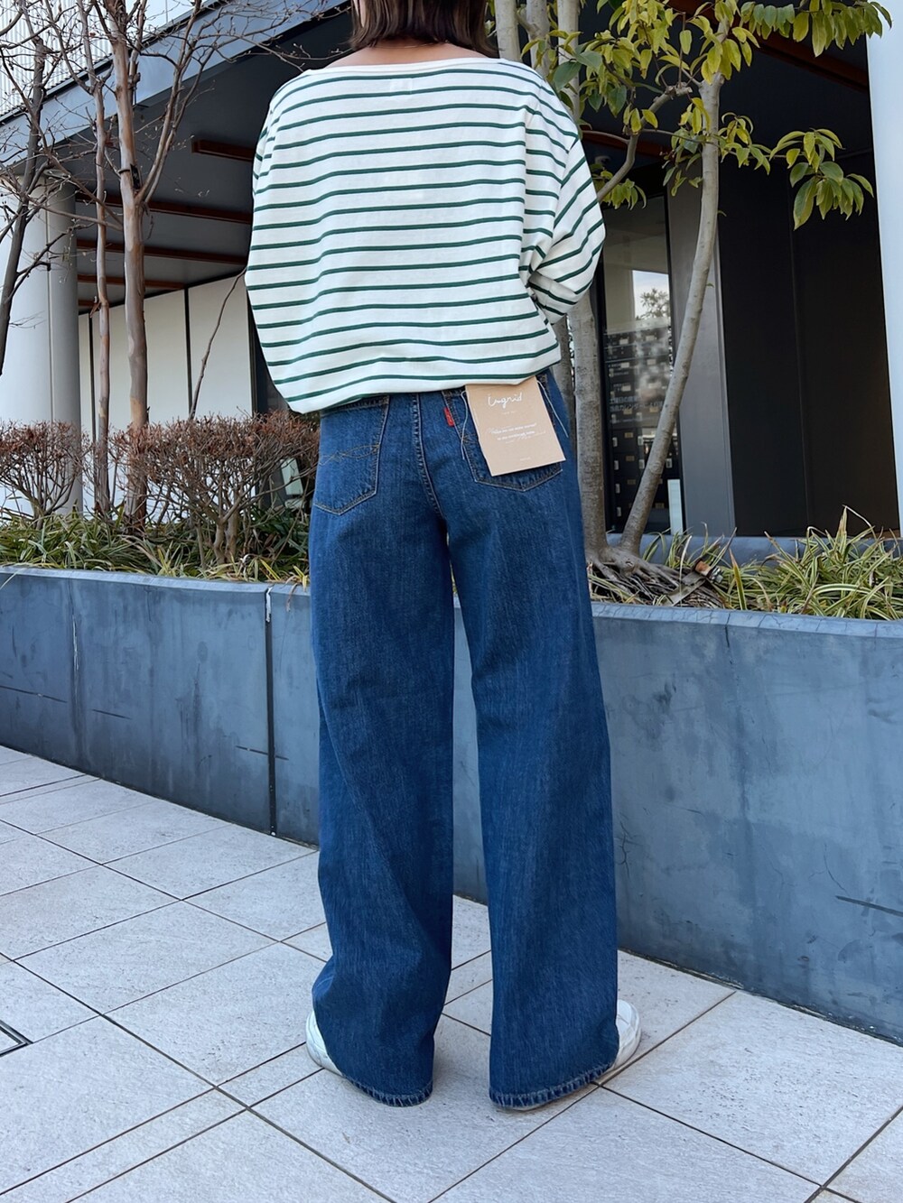 ブルー系のデニムパンツ、グリーン系のTシャツ/カットソーを着用したレディースの冬コーディネートの4枚目の写真