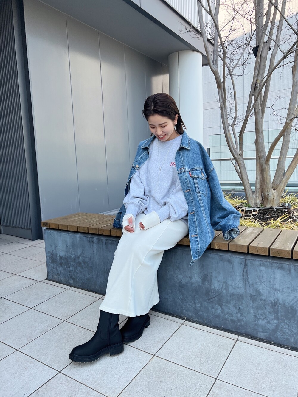 ブルー系のデニムジャケット、グレー系のスウェット、ホワイト系のワンピースを着用したレディースの冬コーディネートの6枚目の写真