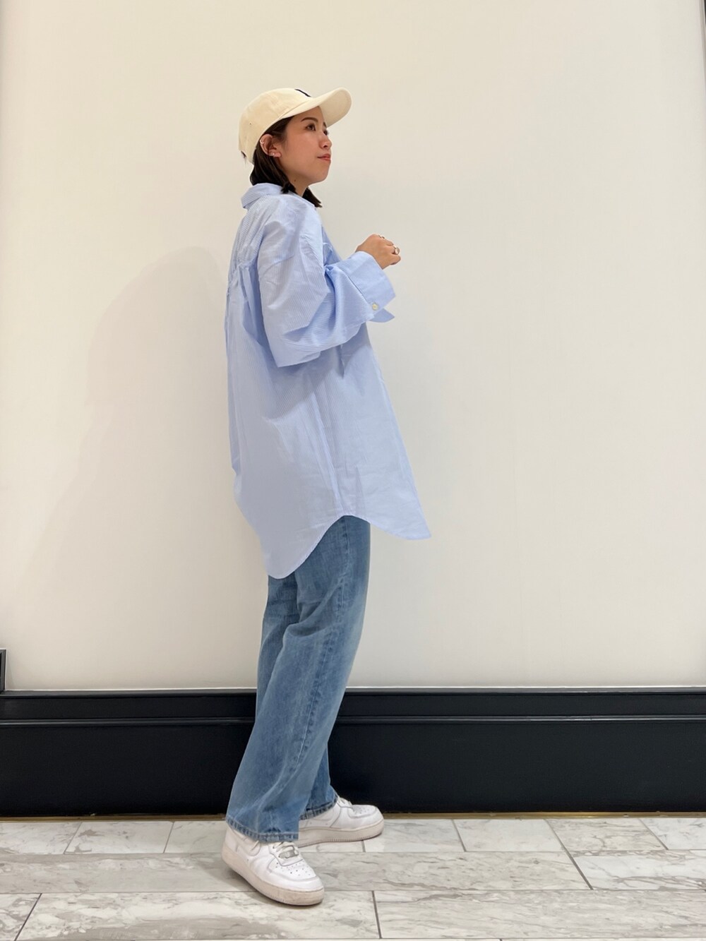 ブルー系のデニムパンツ、その他のシャツ/ブラウス、ホワイト系のキャップを着用したレディースの春コーディネートの5枚目の写真