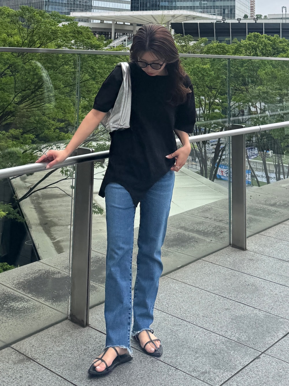 ブラック系のTシャツ/カットソー、ブルー系のデニムパンツを着用したレディースの春コーディネートの2枚目の写真