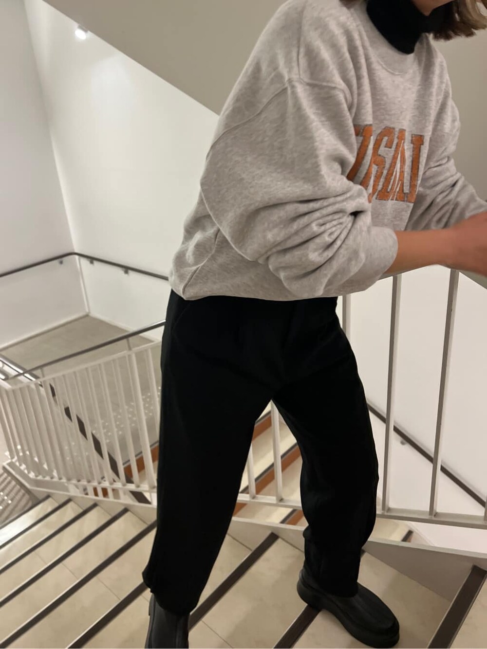 ブラック系のその他パンツ、ブラック系のブーツ、グレー系のスウェットを着用したレディースの冬コーディネートの4枚目の写真