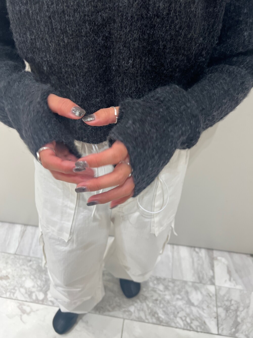 ブラック系のブーツ、ホワイト系のカーゴパンツ、グレー系のニット/セーターを着用したレディースの秋コーディネートの9枚目の写真