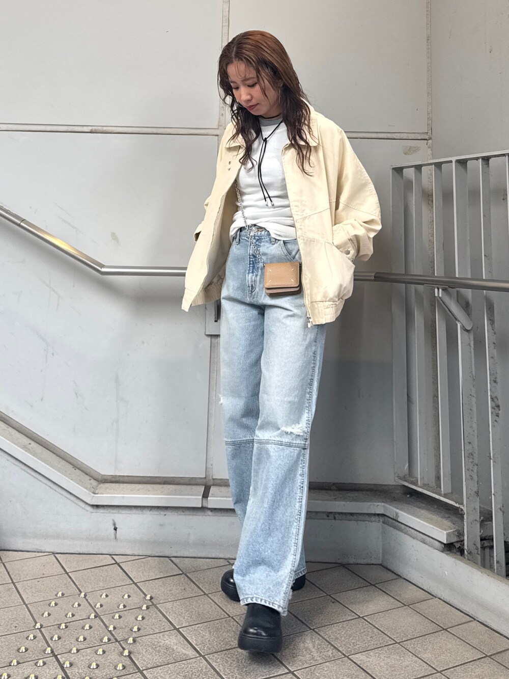 ブルー系のデニムパンツ、ベージュ系のブルゾン、ホワイト系のTシャツ/カットソーを着用したレディースの冬コーディネートの3枚目の写真