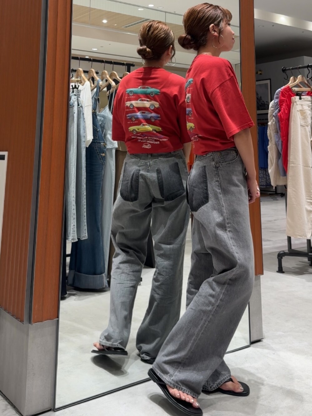 レッド系のTシャツ/カットソー、ブラック系のデニムパンツ、ブラック系のサンダルを着用したレディースの夏コーディネートの3枚目の写真