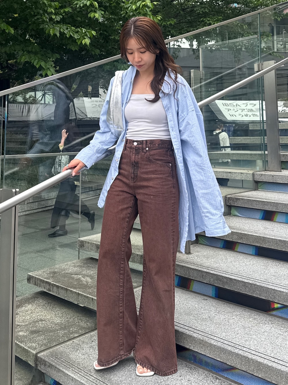 ブラウン系のデニムパンツ、ブルー系のシャツ/ブラウスを着用したレディースの春コーディネートの3枚目の写真