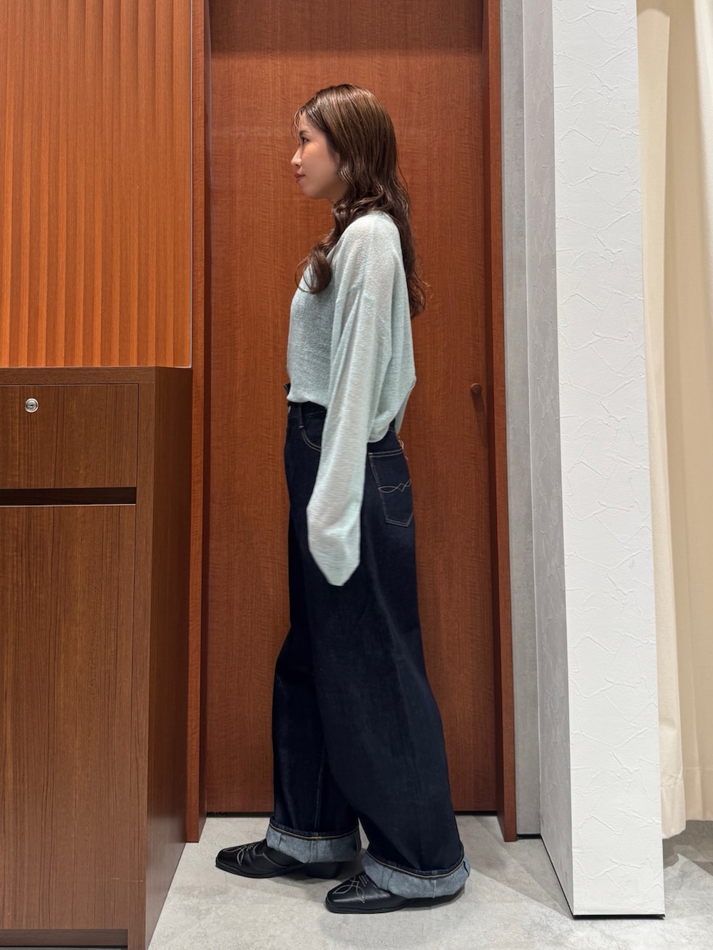 グリーン系のニット/セーター、ブルー系のデニムパンツ、ブラック系のその他シューズを着用したレディースの秋コーディネートの5枚目の写真