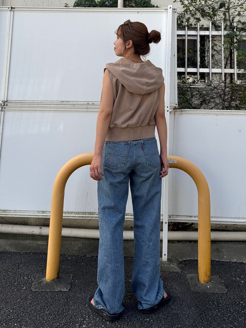 ベージュ系のパーカー、ブルー系のデニムパンツを着用したレディースの夏コーディネートの4枚目の写真