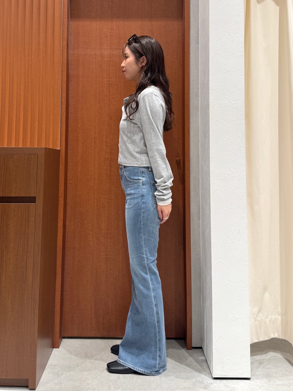 ブルー系のデニムパンツ、ブラック系のサンダル、グレー系のTシャツ/カットソーを着用したレディースの秋コーディネートの3枚目の写真