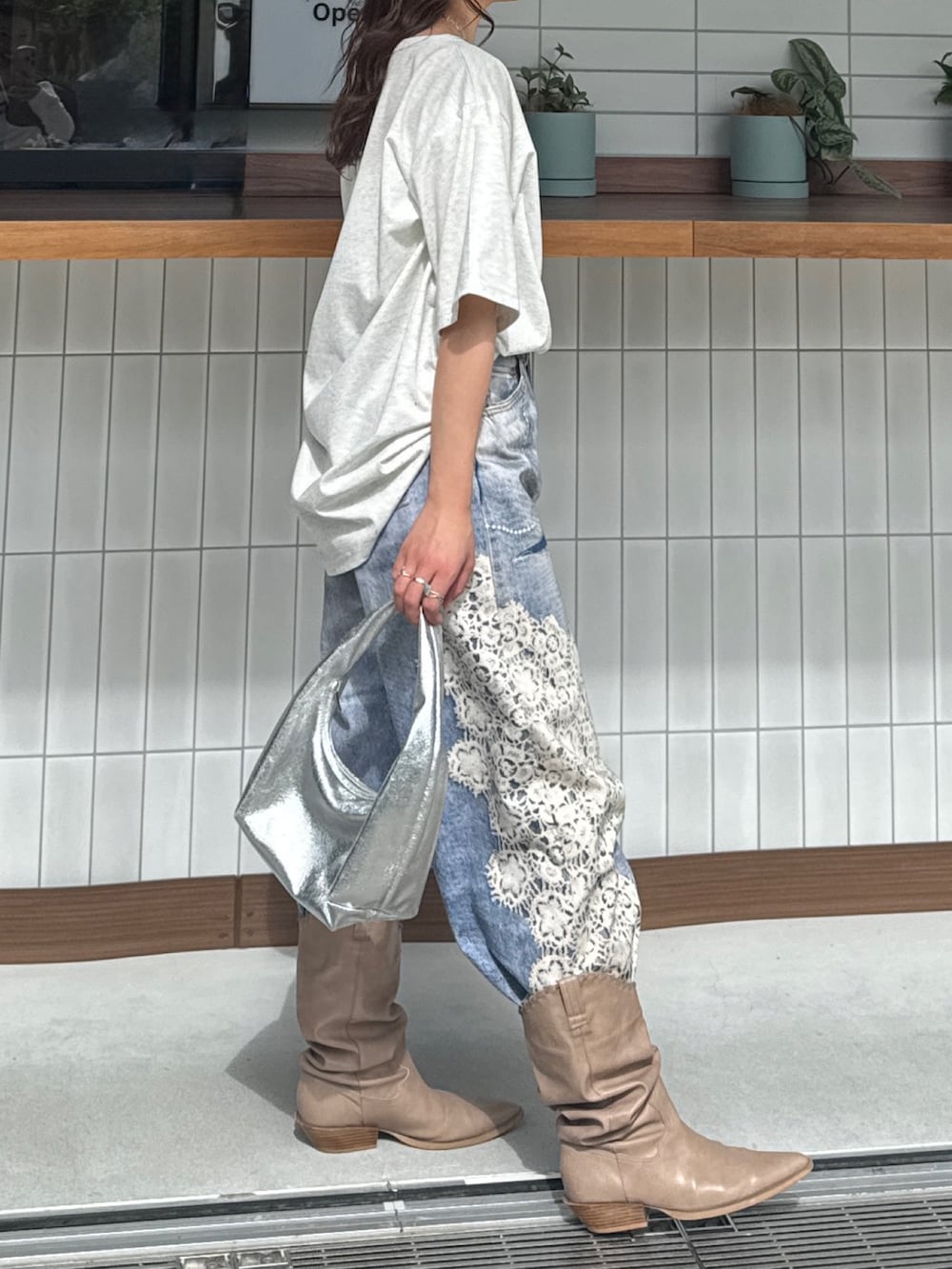 グレー系のTシャツ/カットソー、ブルー系のデニムパンツ、ベージュ系のブーツを着用したレディースの春コーディネートの4枚目の写真