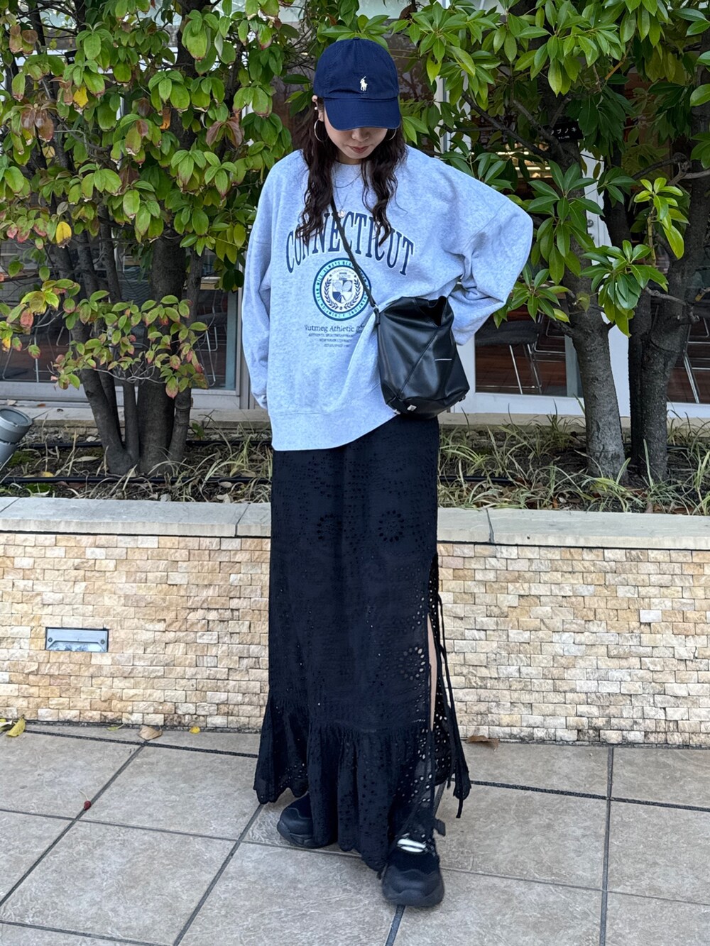 ブラック系のスカート、グレー系のスウェット、ブラック系のスニーカーを着用したレディースの冬コーディネートの2枚目の写真