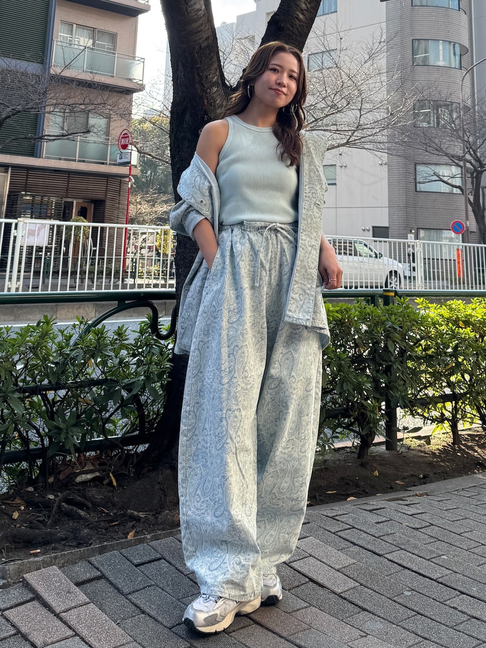 ブルー系のカバーオール、ブルー系のデニムパンツ、ブルー系のタンクトップを着用したレディースの春コーディネートの5枚目の写真