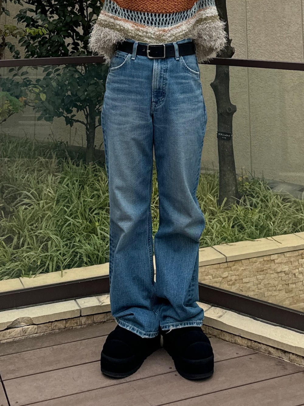 ブルー系のニット/セーター、ブラック系のTシャツ/カットソー、ブルー系のデニムパンツを着用したレディースの秋コーディネートの5枚目の写真