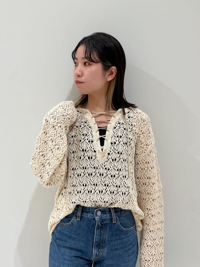 ブラック系のサンダル、ブラック系のハンドバッグ、ブルー系のデニムパンツを着用したレディースの春コーディネートの6枚目の写真