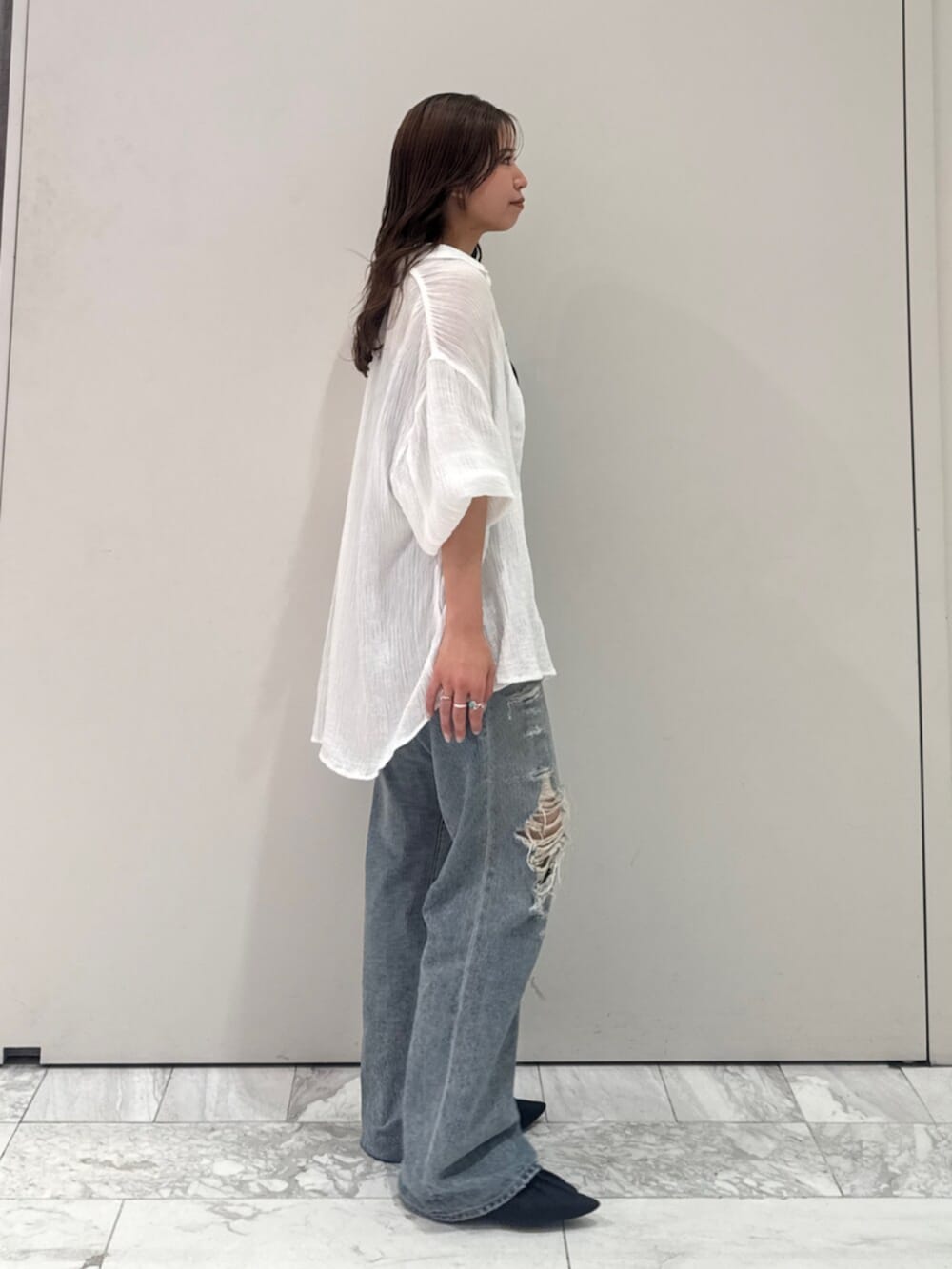 ブラック系のパンプス、ホワイト系のシャツ/ブラウス、ブルー系のデニムパンツを着用したレディースの春コーディネートの4枚目の写真