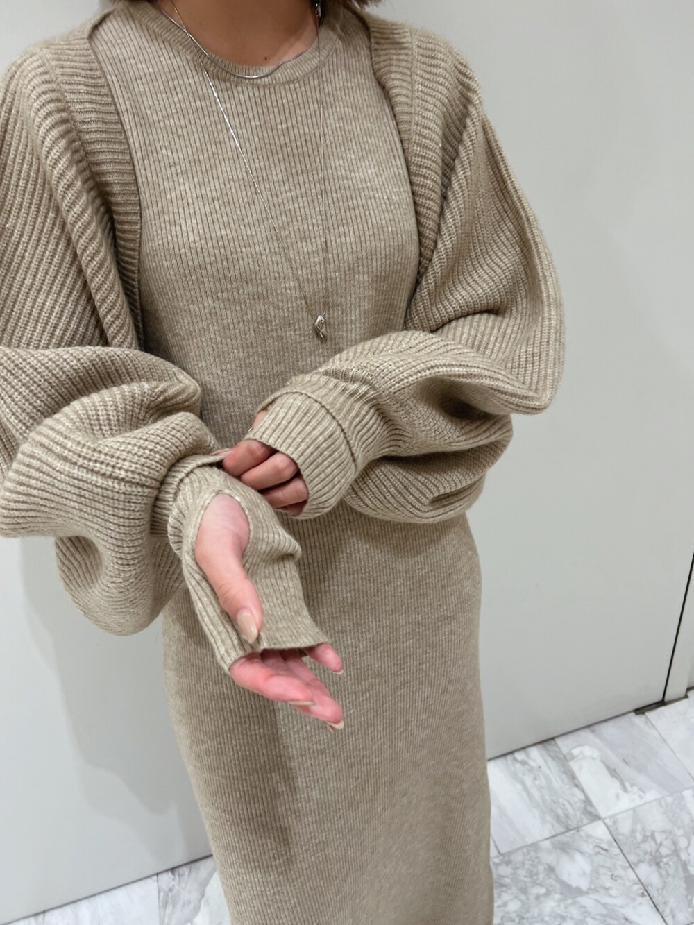 グレー系のワンピース、ブラウン系のブーツを着用したレディースの秋コーディネートの8枚目の写真