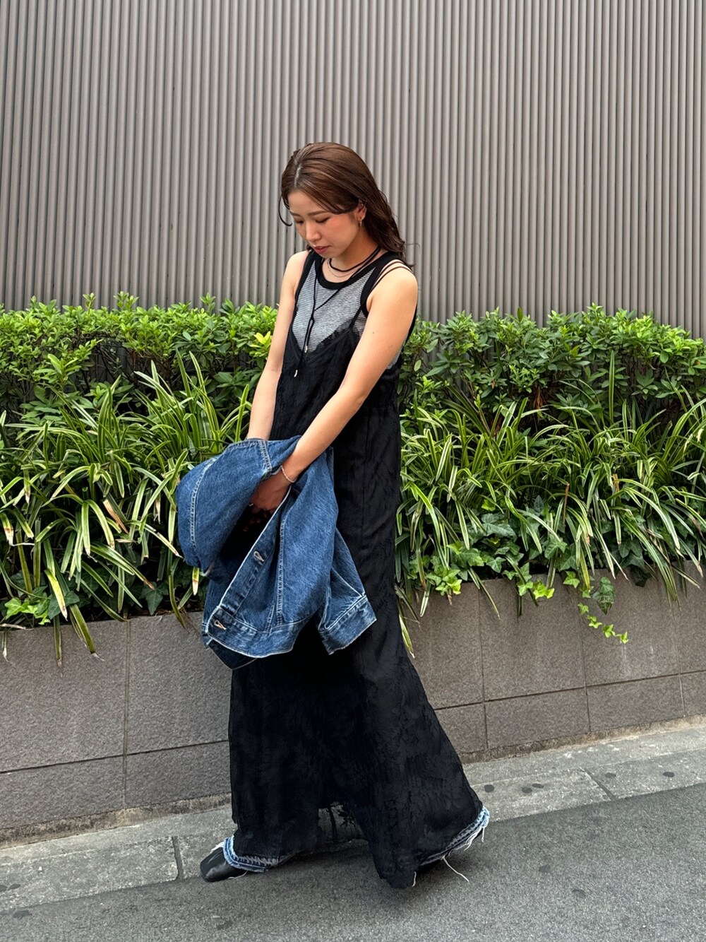 ブラック系のワンピース、ブルー系のデニムジャケット、グレー系のタンクトップを着用したレディースの夏コーディネートの4枚目の写真