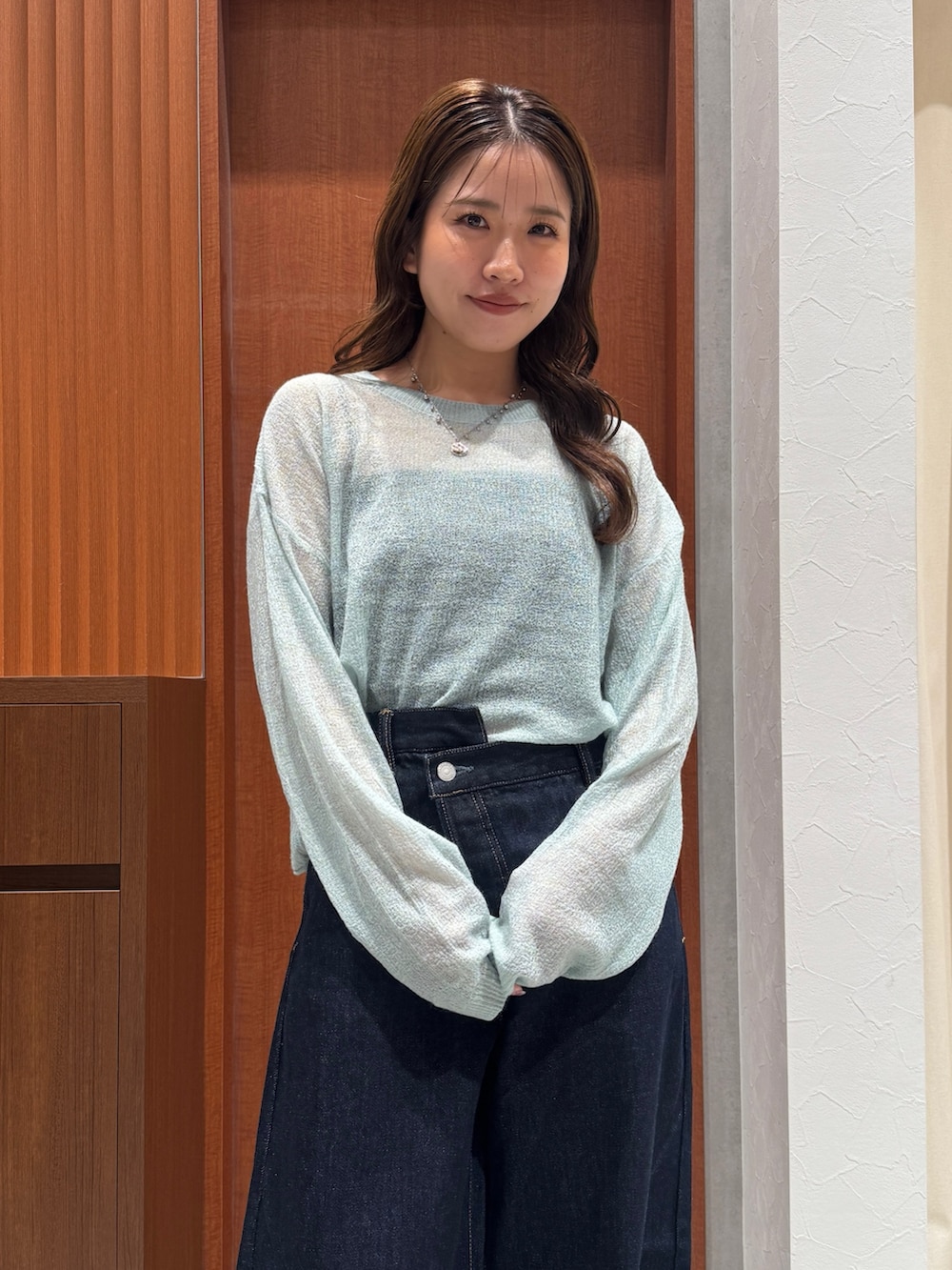 グリーン系のニット/セーター、ブルー系のデニムパンツ、ブラック系のその他シューズを着用したレディースの秋コーディネートの7枚目の写真