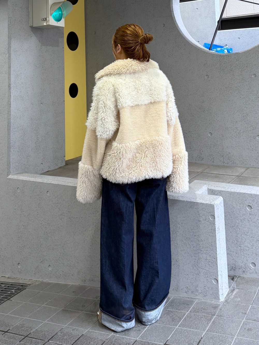 ホワイト系のブルゾン、シルバー系のパンプス、ブルー系のデニムパンツを着用したレディースの秋コーディネートの7枚目の写真