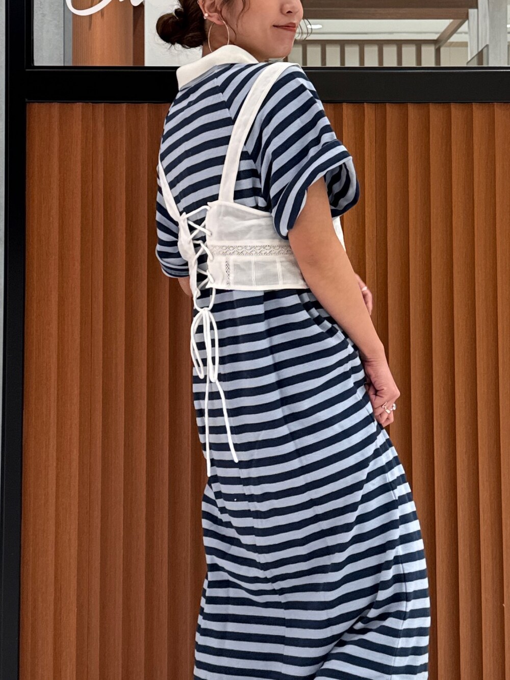 ホワイト系のキャミソール、ブルー系のワンピース、ブラック系のスニーカーを着用したレディースの春コーディネートの7枚目の写真