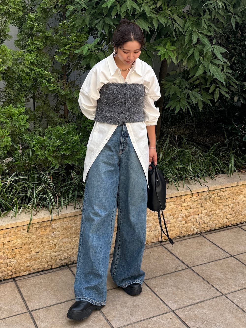 ブルー系のデニムパンツ、ホワイト系のシャツ/ブラウス、ブラック系のニット/セーターを着用したレディースの秋コーディネートの3枚目の写真