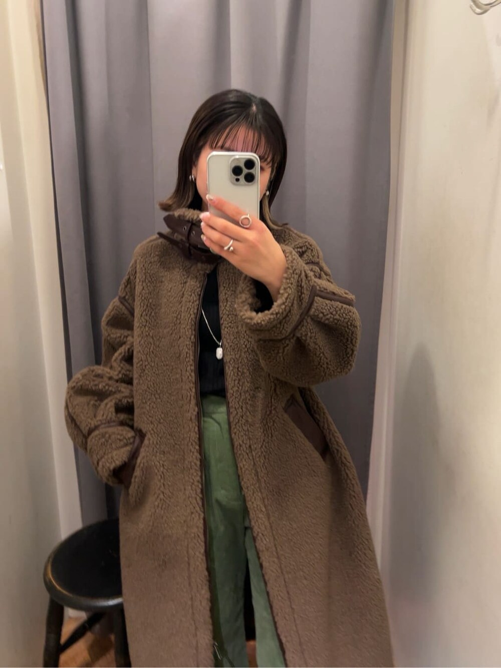 ブラウン系のムートンコート、グリーン系のその他パンツを着用したレディースの冬コーディネートの3枚目の写真