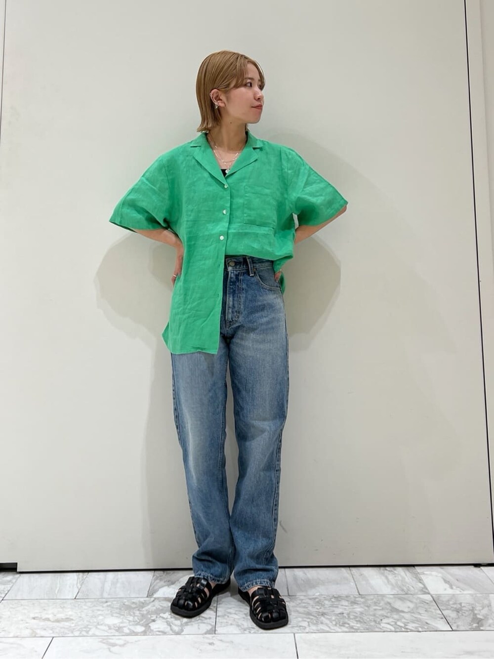 グリーン系のシャツ/ブラウス、ブルー系のデニムパンツを着用したレディースの春コーディネートの2枚目の写真