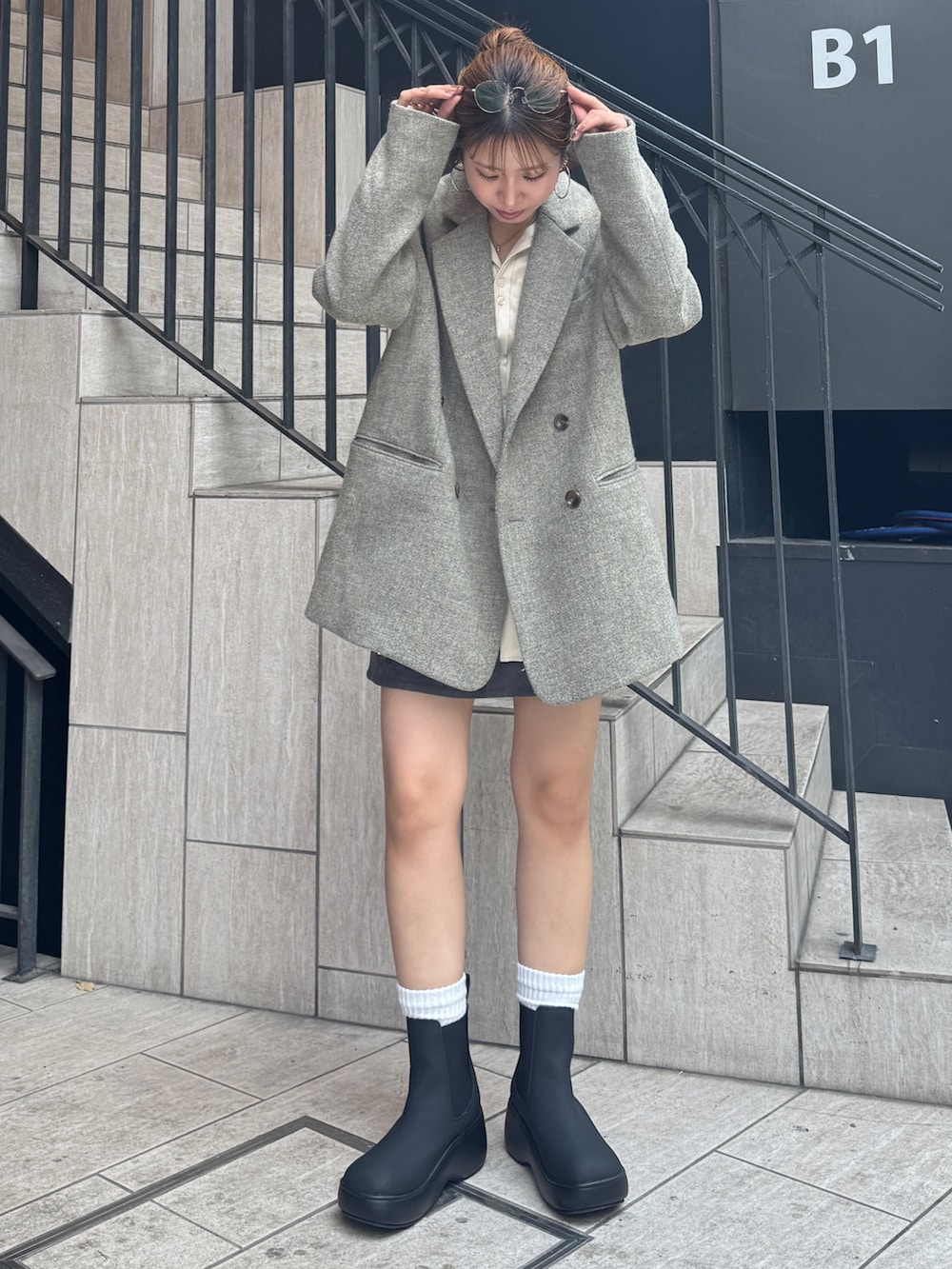 グレー系のスカート、ホワイト系のシャツ/ブラウス、グレー系のテーラードジャケットを着用したレディースの秋コーディネートの2枚目の写真