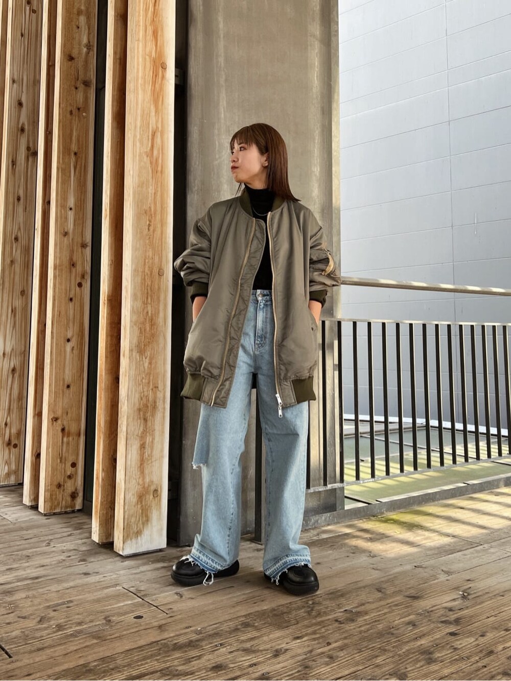 グリーン系のMA-1、ブルー系のデニムパンツ、ブルー系のデニムパンツを着用したレディースの秋コーディネートの3枚目の写真