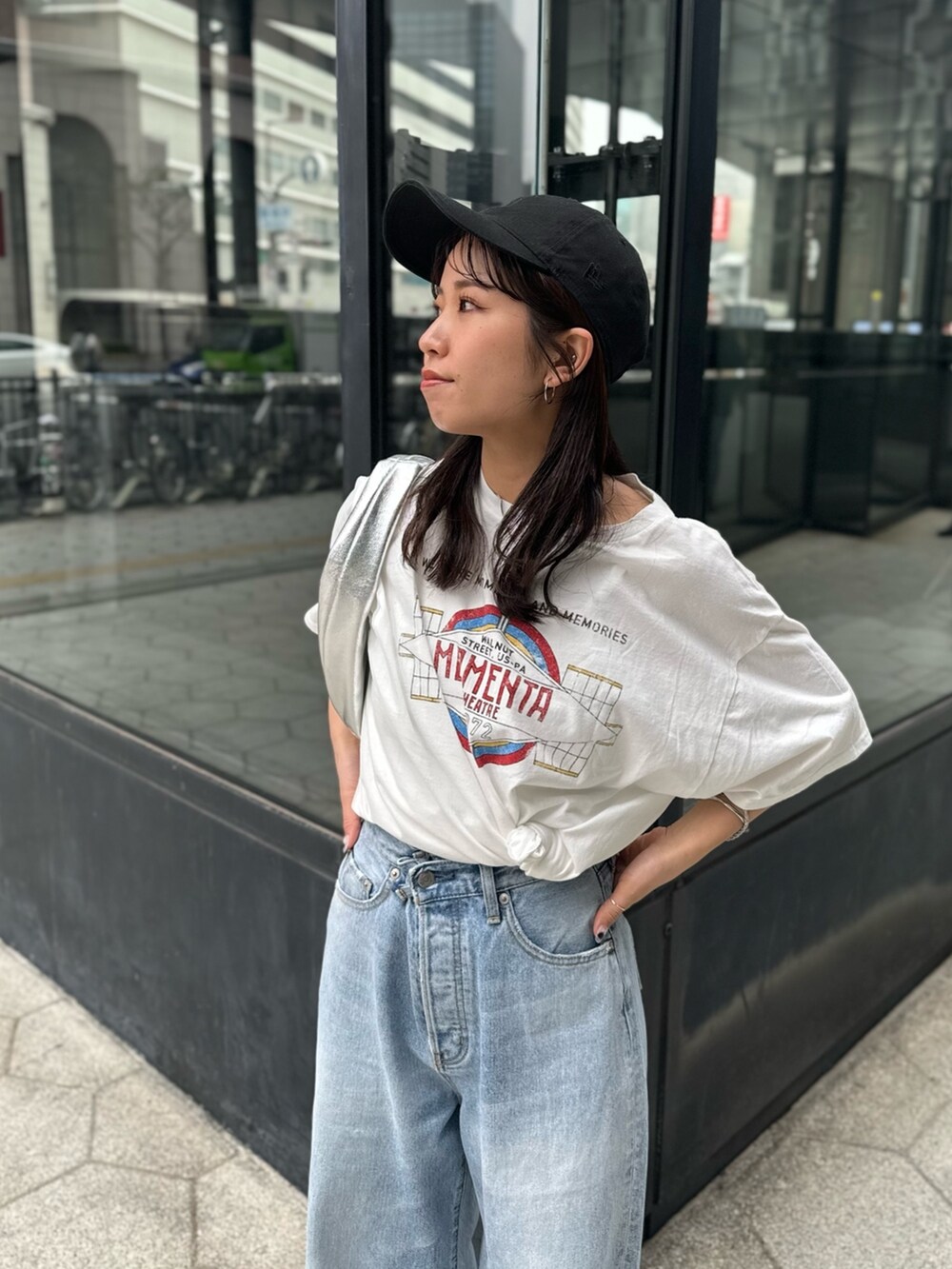 ブルー系のデニムパンツ、ホワイト系のTシャツ/カットソー、シルバー系のハンドバッグを着用したレディースの春コーディネートの3枚目の写真